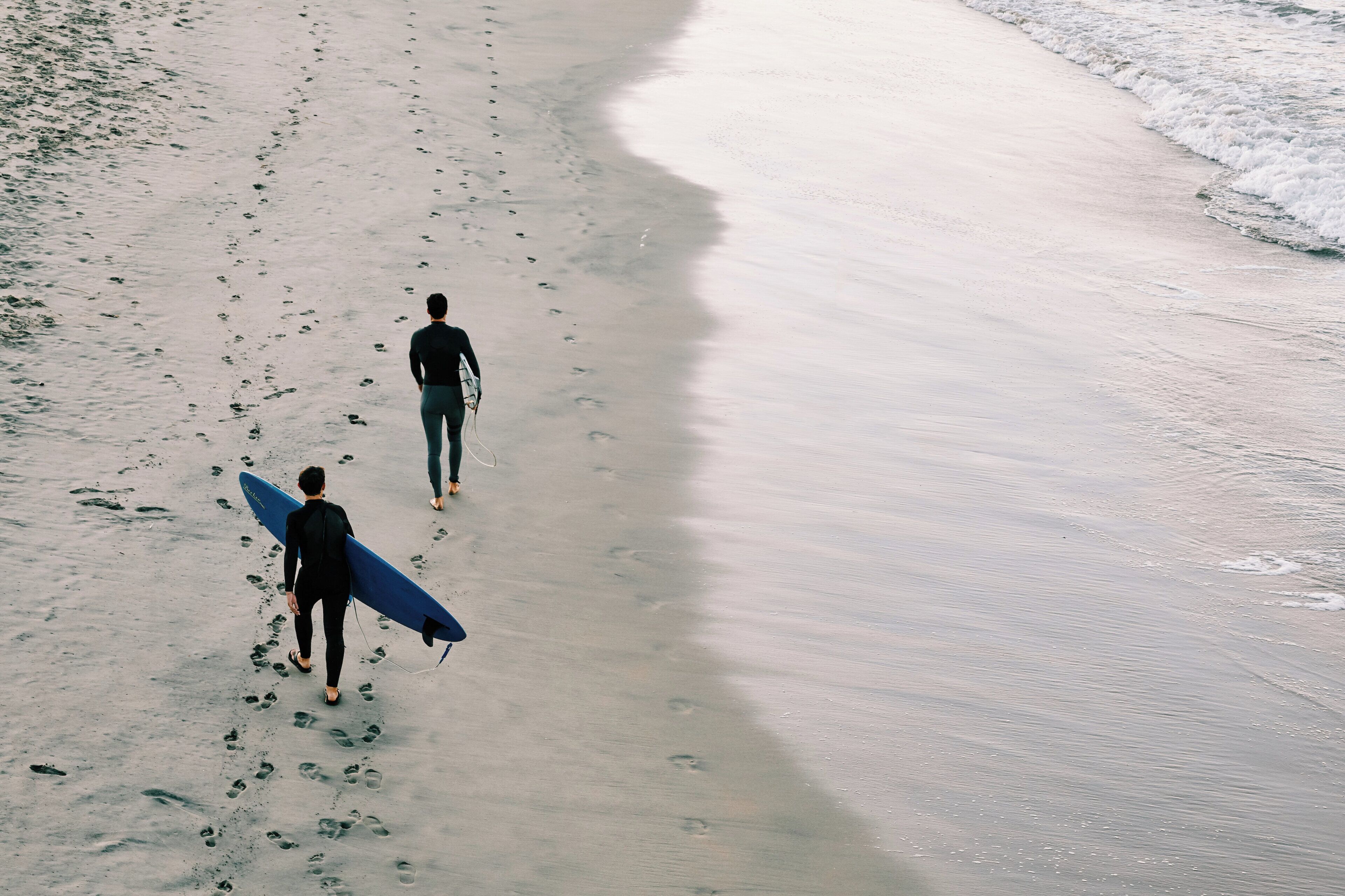 A beach with footprints leading towards the water.