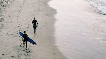A beach with footprints leading towards the water.