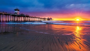 A pier extending into the ocean with a lighthouse at the end.