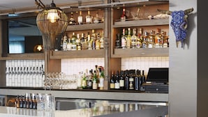 A bar area with a marble countertop, bar stools, a wine rack, and a decorative skull on the wall.
