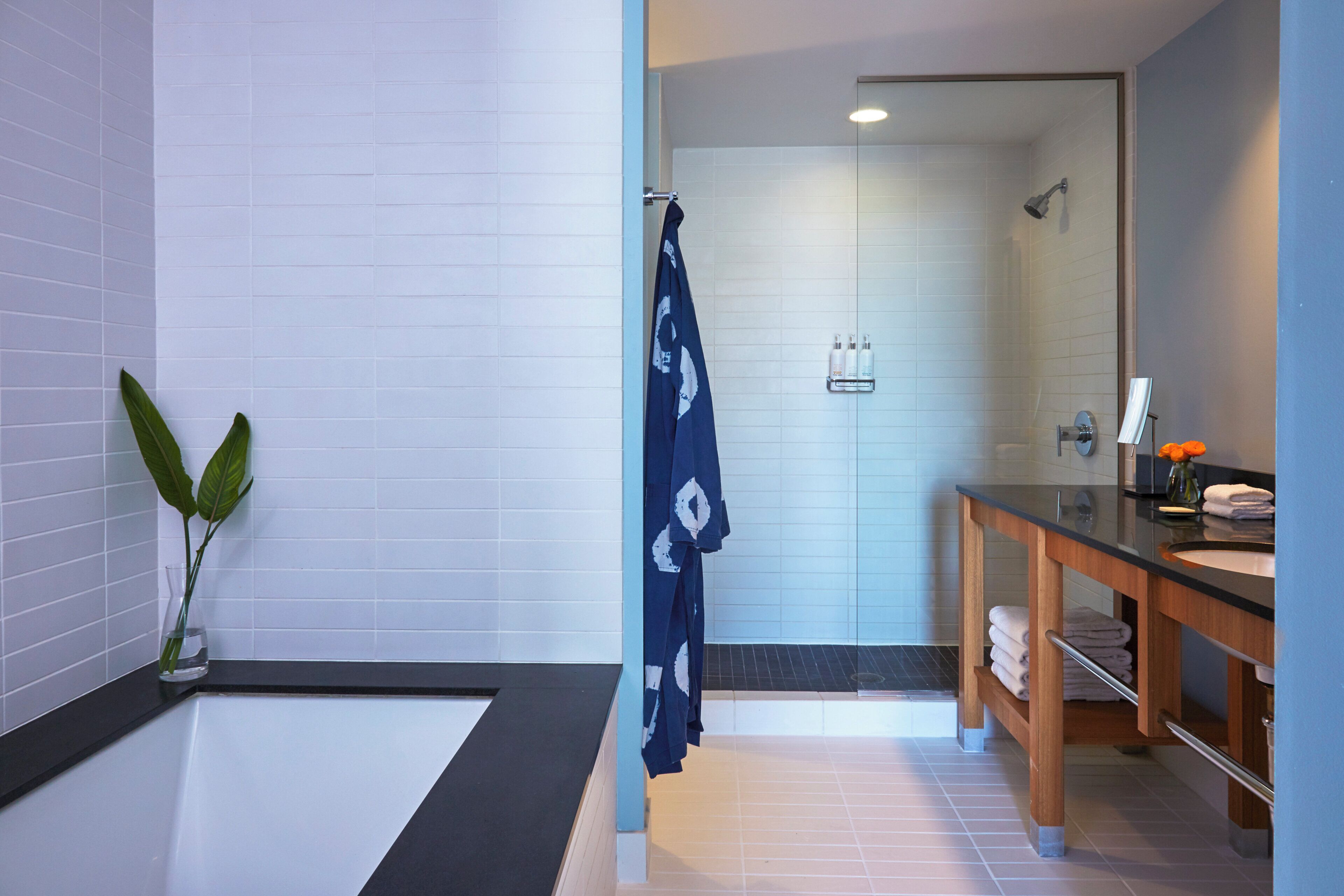 A modern bathroom with a bathtub, a shower, and a vanity with a mirror.