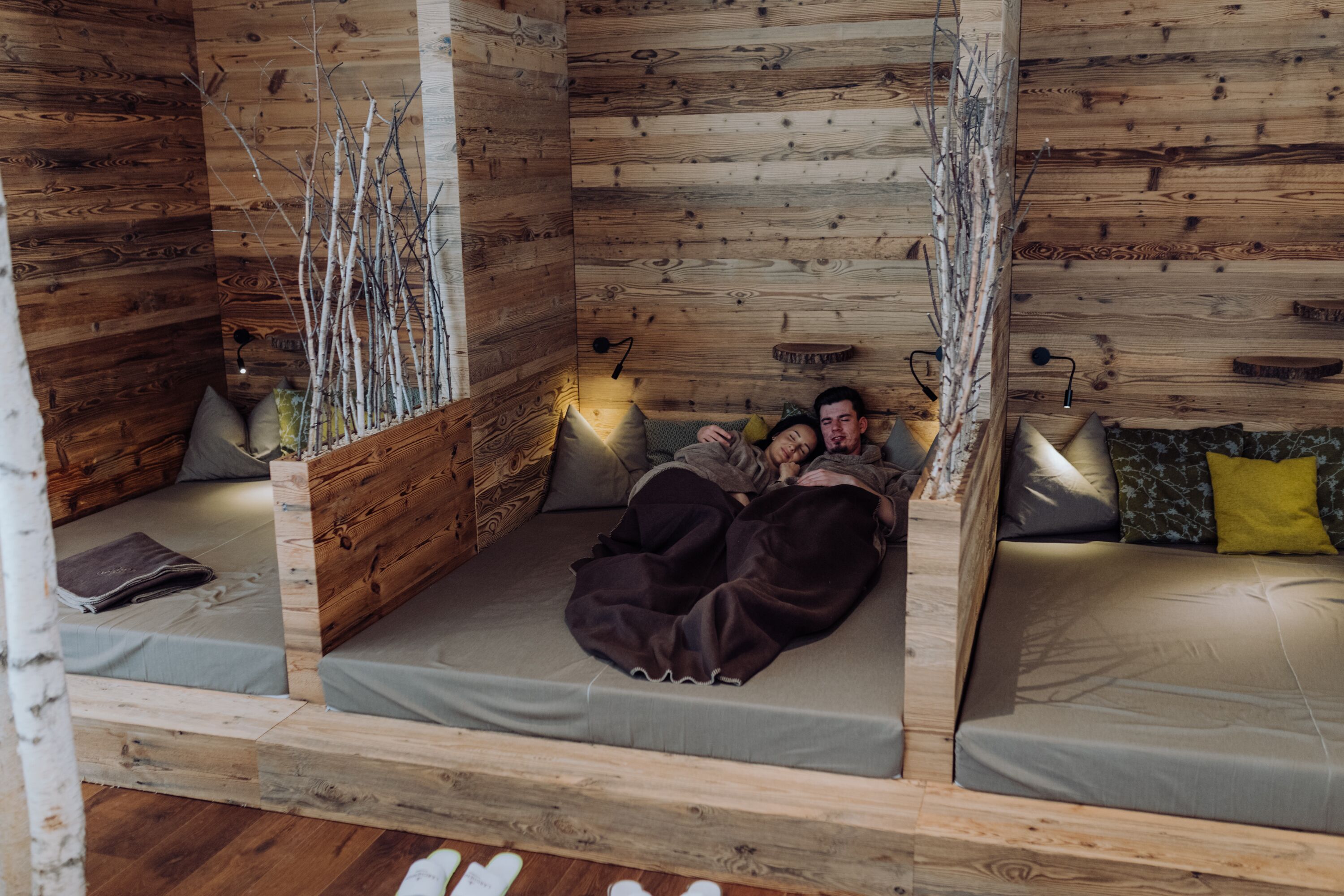Ein gemütliches Holzhaus mit einem Bett und einer Sitzecke.