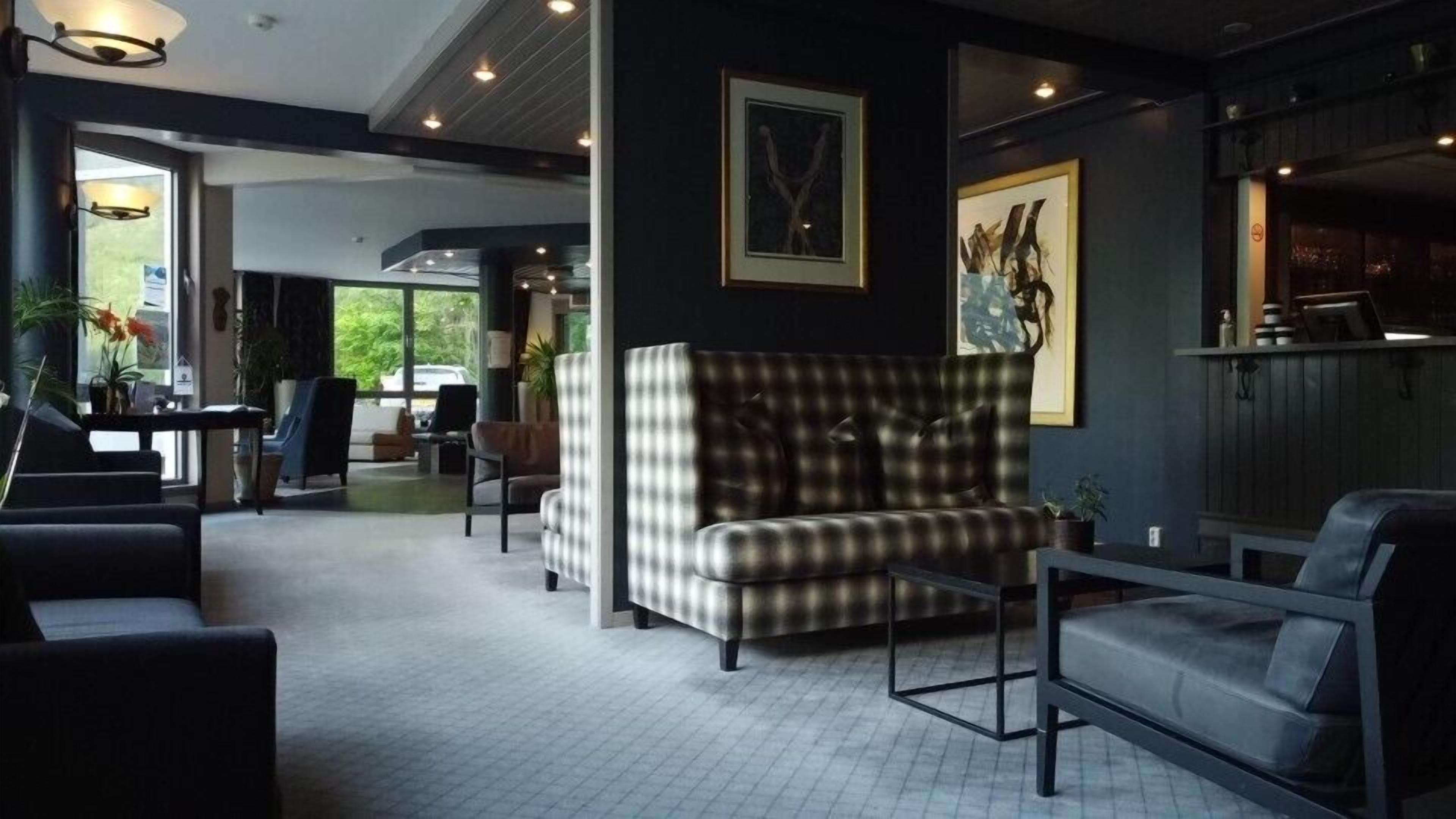 A modern living room with a checkered sofa, a coffee table, and a seating area with a view of the outdoors.