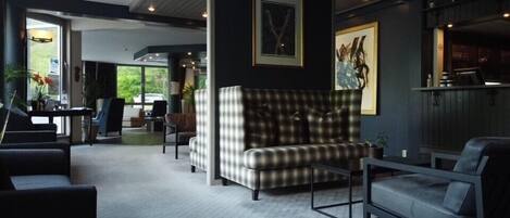 A modern living room with a checkered sofa, a coffee table, and a seating area with a view of the outdoors.