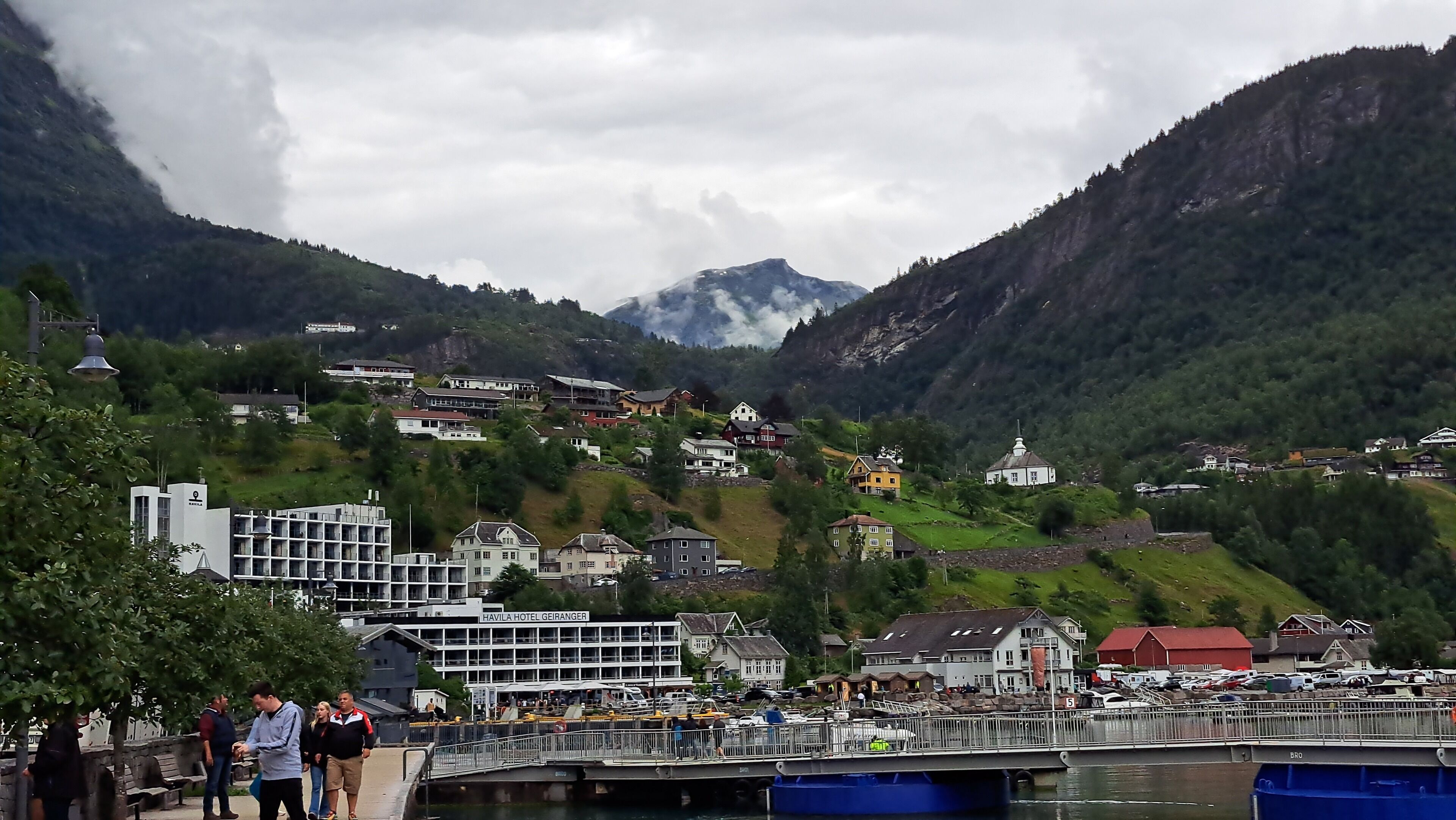 Une ville côtière dotée d’un port de plaisance, d’un hôtel appelé HAVILA HOTEL GEIRANGEI et de maisons construites sur une colline.
