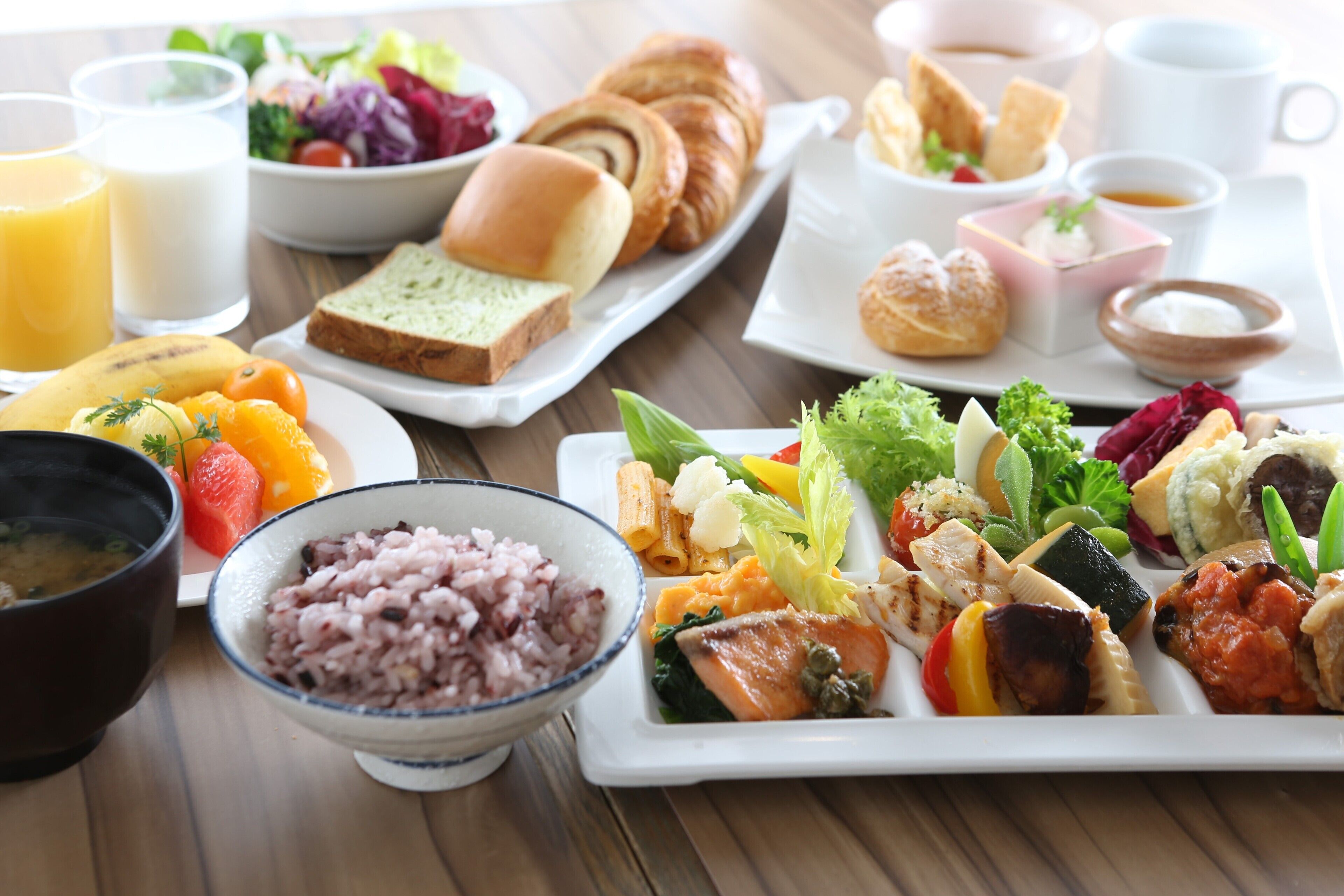 Un ricco buffet della colazione con diverse pietanze, tra cui frutta, verdura e dolci.