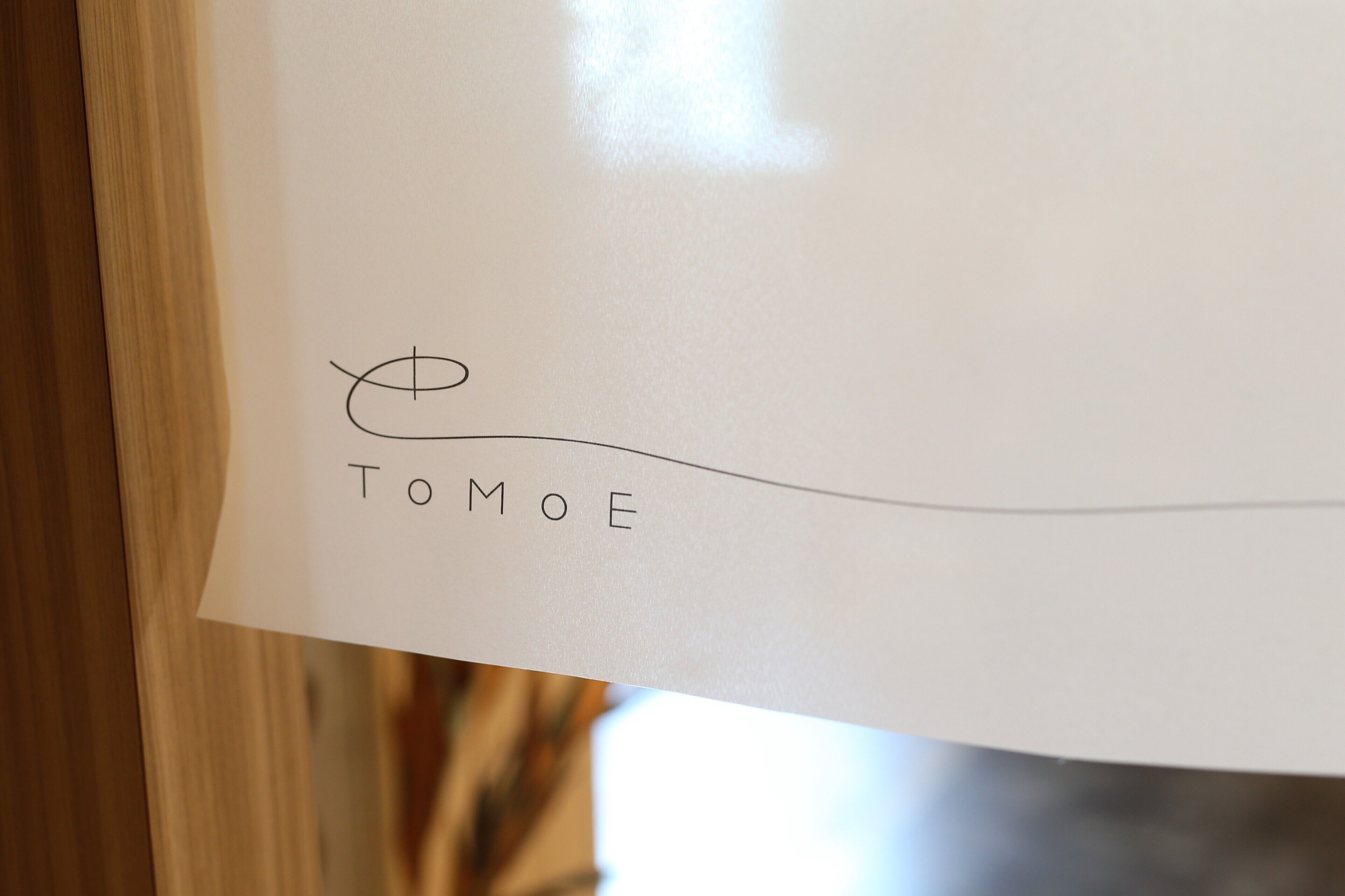 A piece of paper with the name "TOMOE" written on it.