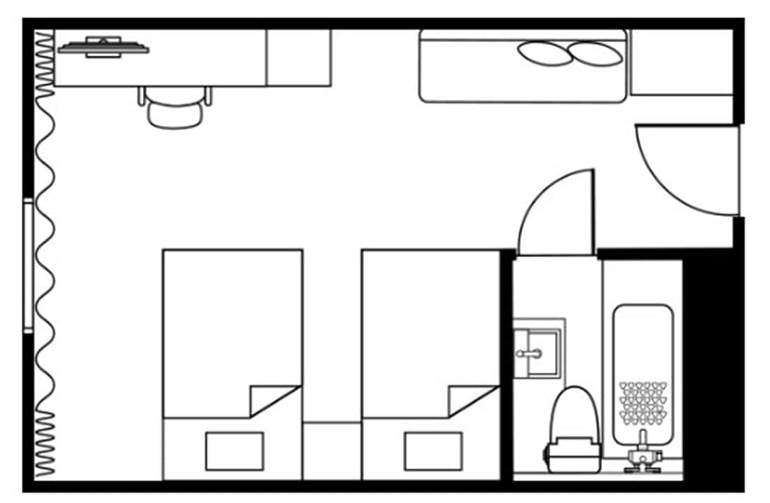 A floor plan of a hotel room with a bed, a bathroom, a kitchenette, and a small seating area.
