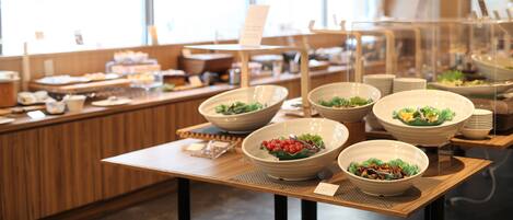 A buffet setup with various dishes and bowls on tables.