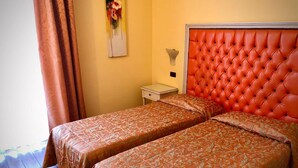 A hotel room with two beds, a red headboard, a nightstand, and a painting on the wall. - Hotel Alle Torri (Mestre)