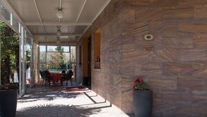 A covered outdoor area with stone walls, a reception sign, and potted plants.
