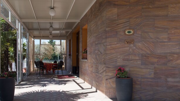 A covered outdoor area with stone walls, a reception sign, and potted plants. - Hotel Alle Torri (Mestre)