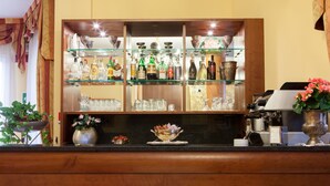 A bar area with shelves of liquor bottles, glasses, and a coffee machine. - Hotel Alle Torri (Mestre)