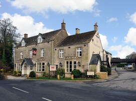 Un edificio de piedra tradicional con un letrero del pub 'The Royal George'.