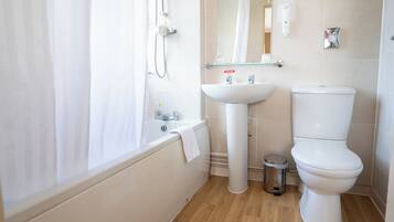 Un baño con bañera, lavabo e inodoro.