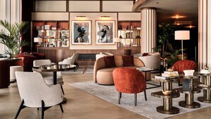 A spacious lobby with a fireplace, comfortable seating, and a well-organized bookshelf. - Radisson Blu Hotel, Hamburg Airport (Hamburg)