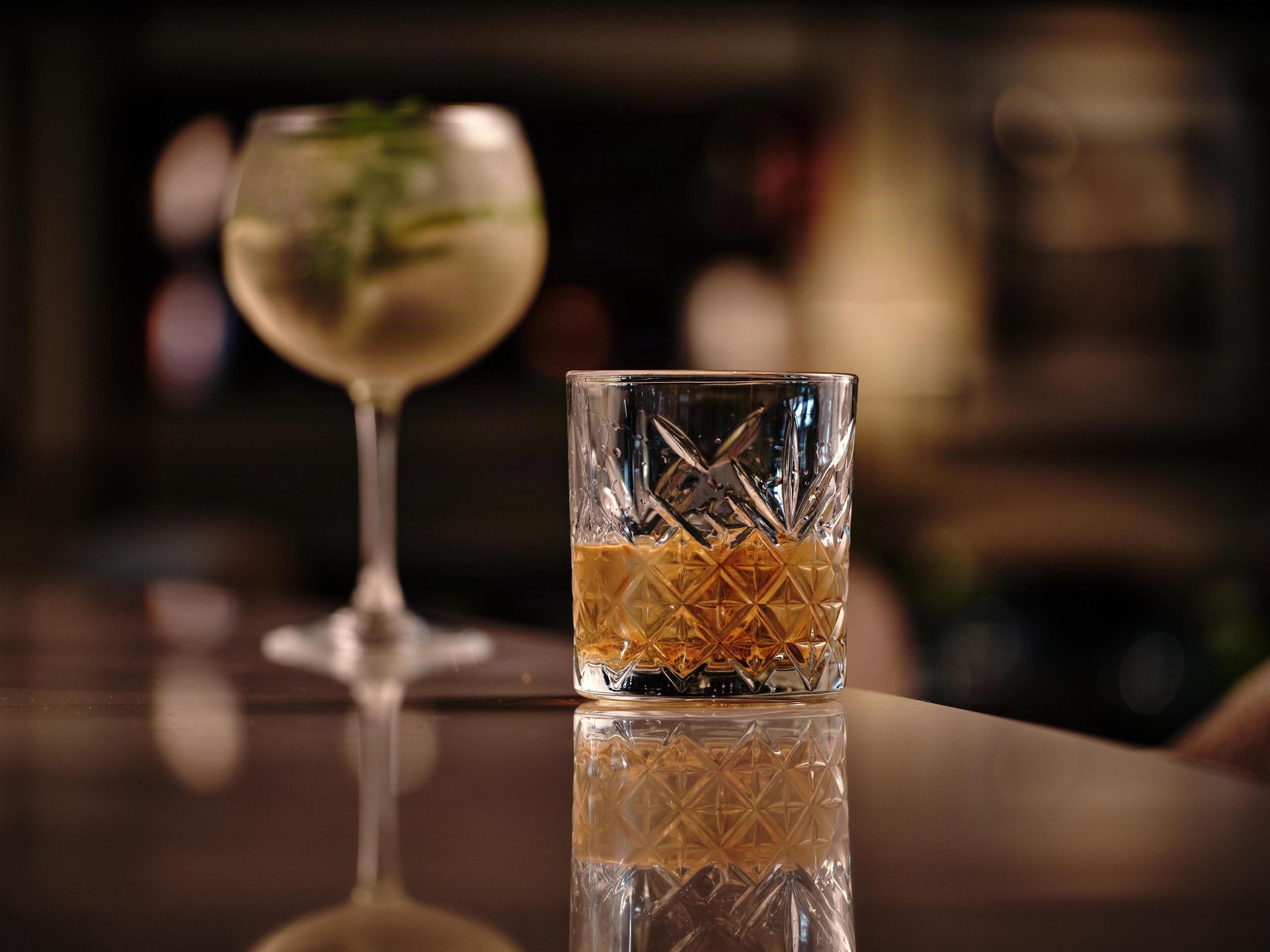 A bar setting with a clear glass and a wine glass.