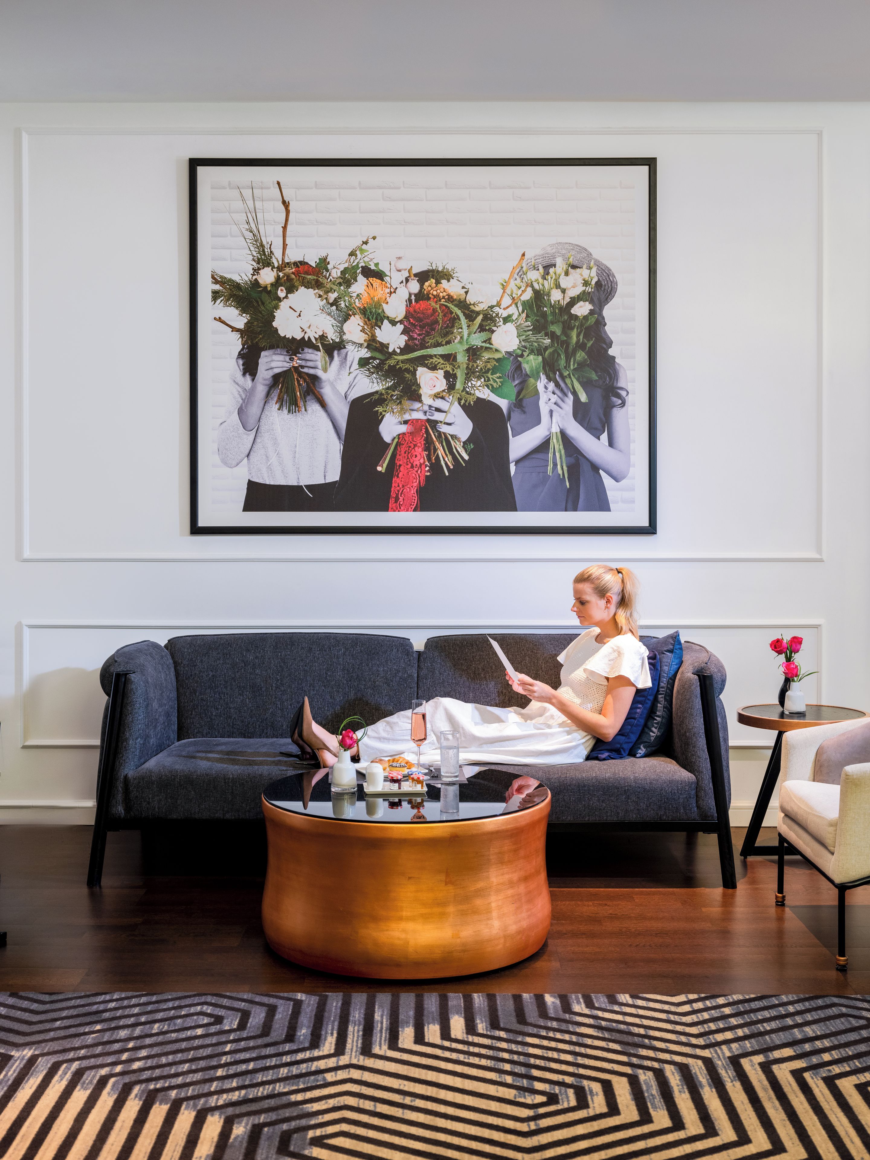 Un salon avec un canapé, une table basse et une œuvre d’art encadrée accrochée au mur.