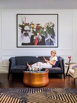 A living room with a sofa, a coffee table, and a framed artwork on the wall.