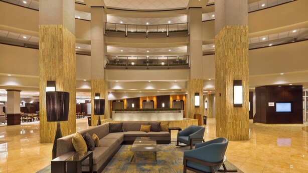A spacious lobby with a central seating area, multiple floors, and a modern design. - Courtyard by Marriott Omaha La Vista (La Vista)