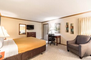 A hotel room with a bed, desk, chair, television, and artwork on the wall. - Econo Lodge Valley City (Valley City)