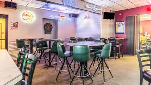 A restaurant with a dartboard, neon signs, and a variety of seating options including tables and bar stools.