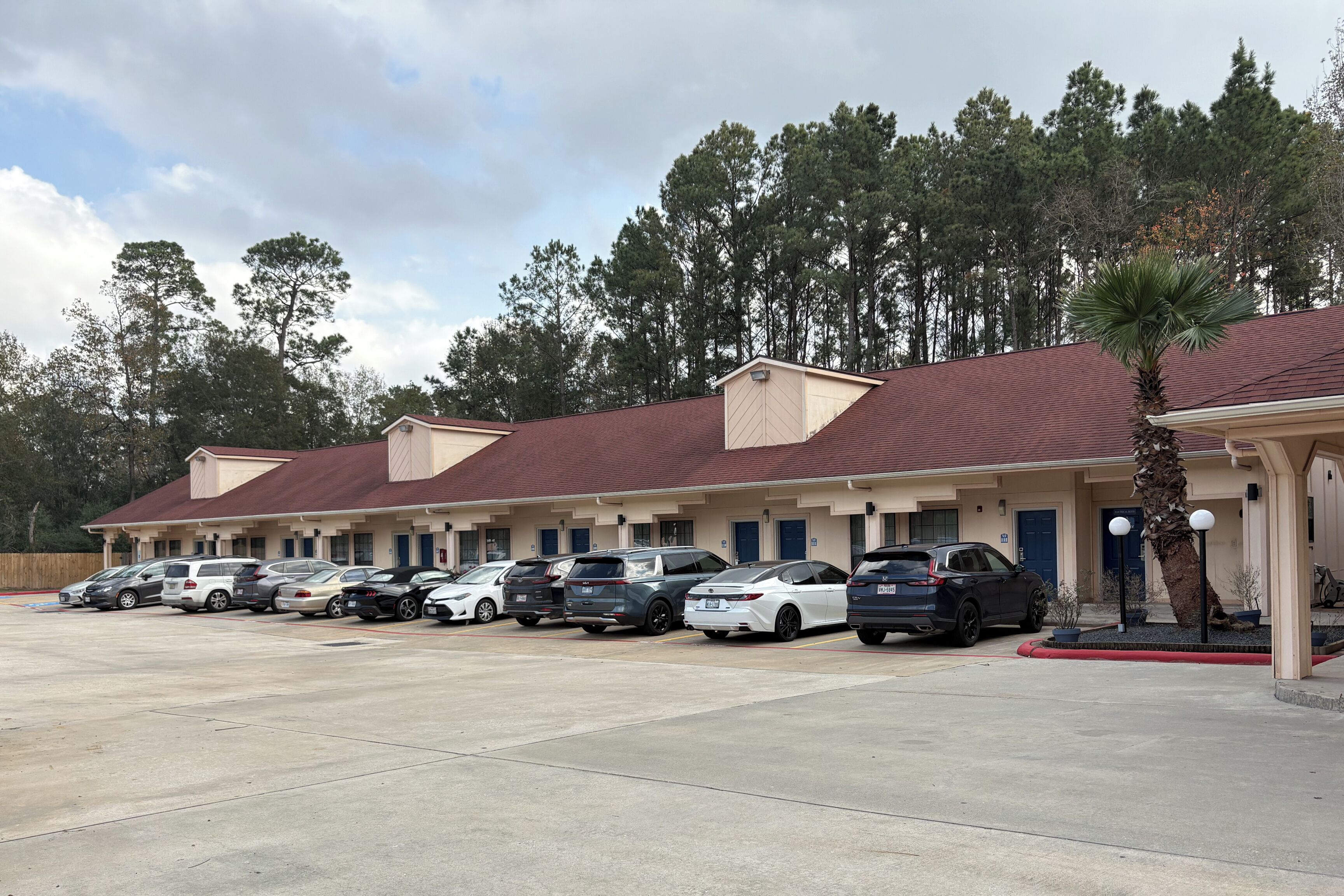A motel with multiple rooms and a parking lot.