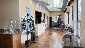 Eine geräumige Lobby mit hoher Decke, Holzböden und einem Weihnachtsbaum.