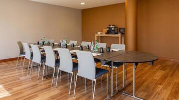 A conference room with a long table, chairs, and a coffee station.