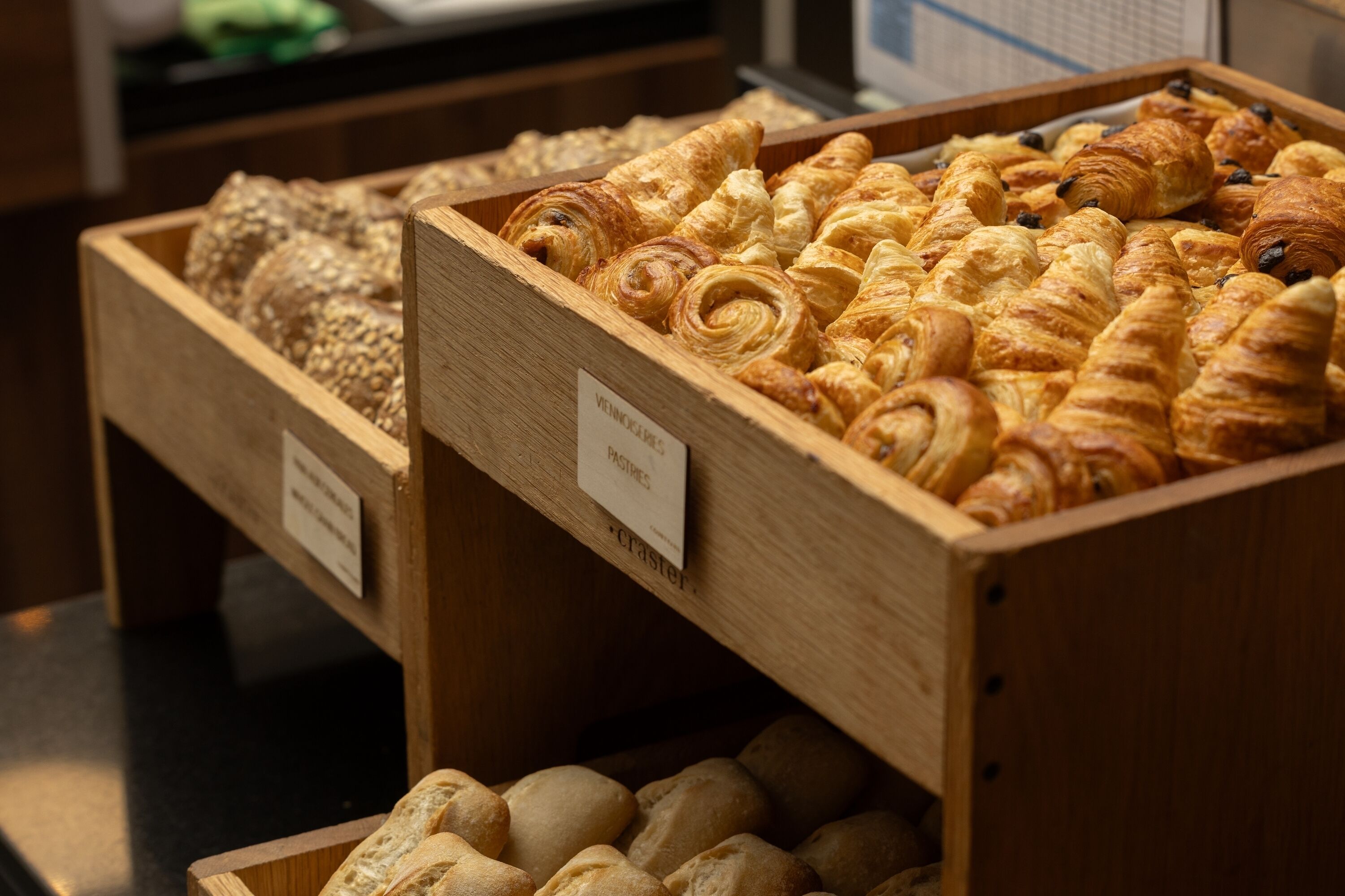 Wooden display cases with pastries and bread.