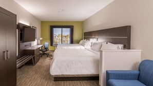 A hotel room with a bed, a desk with a chair, a TV, and a window with a view. - Holiday Inn Express Hotel & Suites Minden by IHG (Minden)