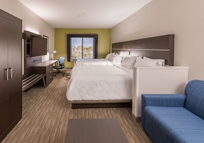 Ein Hotelzimmer mit Bett, Schreibtisch mit Stuhl, Fernseher und Fenster mit Blick.
