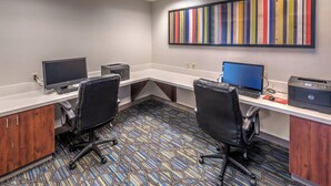 A modern office space with two desks, chairs, computers, and a colorful abstract painting on the wall. - Holiday Inn Express Hotel & Suites Minden by IHG (Minden)