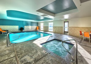 A hotel pool area with a hot tub, seating, and a view of the outdoors. - Holiday Inn Express Hotel & Suites Minden by IHG (Minden)