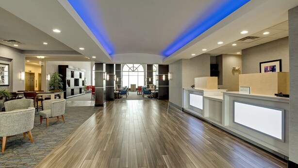 A spacious lobby with a wooden floor, reception desk, seating area, and a large window. - Holiday Inn Express Hotel and Suites Nashville-Opryland by IHG (Nashville)