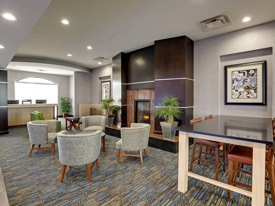 Um lobby moderno com balcão de recepção, área de estar e lareira.