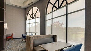 A modern hotel room with a large window, a seating area with a table, and a patterned carpet. - Holiday Inn Express Hotel and Suites Nashville-Opryland by IHG (Nashville)