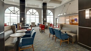 A modern hotel lobby with seating areas, large windows, and a central counter. - Holiday Inn Express Hotel and Suites Nashville-Opryland by IHG (Nashville)