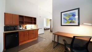 A modern kitchen with wooden cabinets, a microwave, and a coffee maker. There is a dining area with a table and chairs. - Holiday Inn Express Hotel and Suites Mankato East by IHG (Mankato)