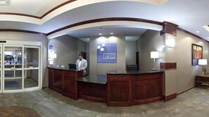 A reception area with a curved desk, a receptionist, and a glass door entrance. - Holiday Inn Express Hotel and Suites Fort Stockton by IHG (Fort Stockton)