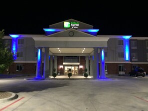 A Holiday Inn Express & Suites building with a prominent entrance, columns, and a parking lot. - Holiday Inn Express Hotel and Suites Fort Stockton by IHG (Fort Stockton)
