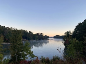 A calm lake surrounded by dense trees, with boats docked on the shore.