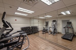 A gym with exercise equipment, including treadmills, a stationary bike, and dumbbells. - Holiday Inn Express Hotel & Suites Corpus Christi by IHG (Corpus Christi)