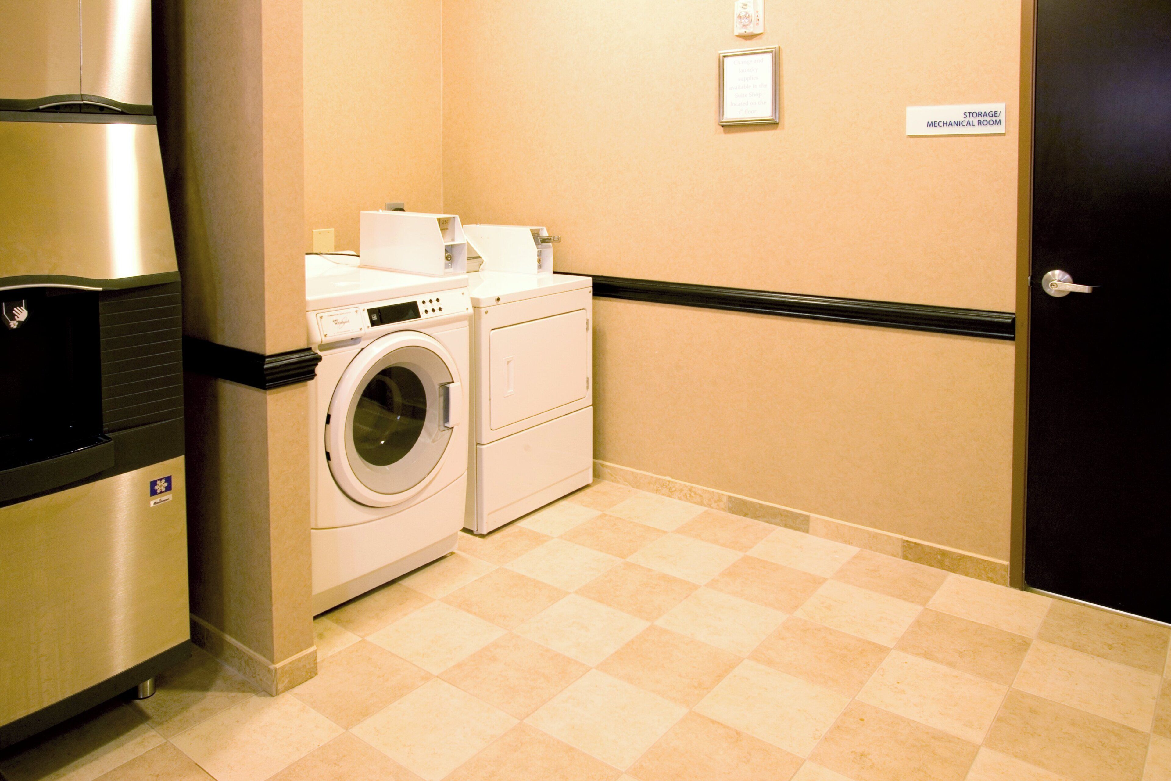 A laundry room with a washing machine, dryer, and a refrigerator.