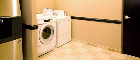 Ein Waschraum mit Waschmaschine, Trockner und Kühlschrank.