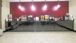 Una larga barra con diversos electrodomésticos y provisiones, probablemente para un área de autoservicio.