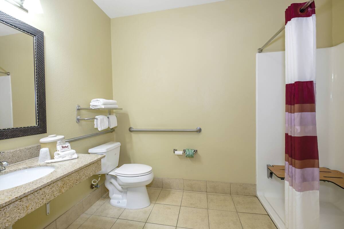 A bathroom with a sink, toilet, and shower.