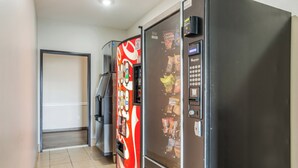 Un couloir avec des distributeurs automatiques et un réfrigérateur.