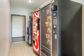 A hallway with vending machines and a refrigerator.