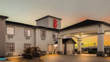 A hotel with a flat roof, multiple windows, and a sign above the entrance.
